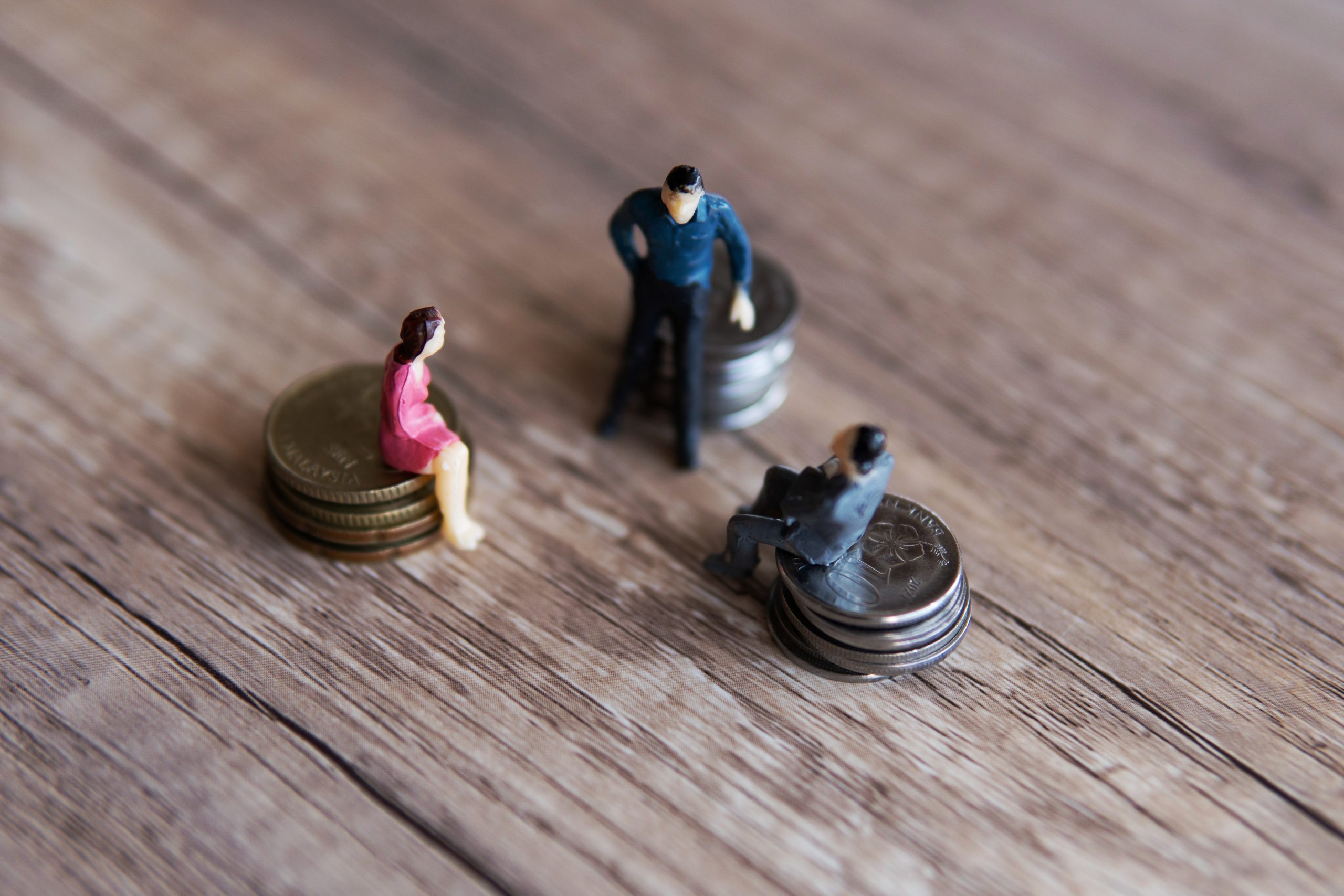 Businessmen figurine and stack of coins. Business meeting, shareholder and funding concept.