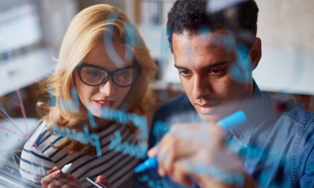 couple planning by writing on a transparent whiteboard